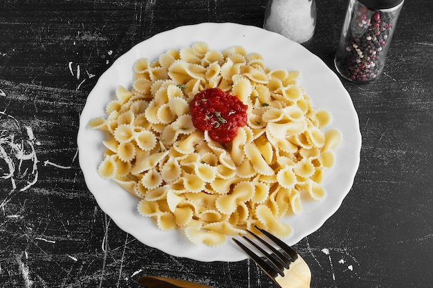 Pasta in salsa di peperoncino rosso in un piatto bianco.