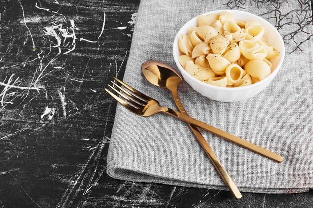 Pasta in tazza di ceramica con set di posate.