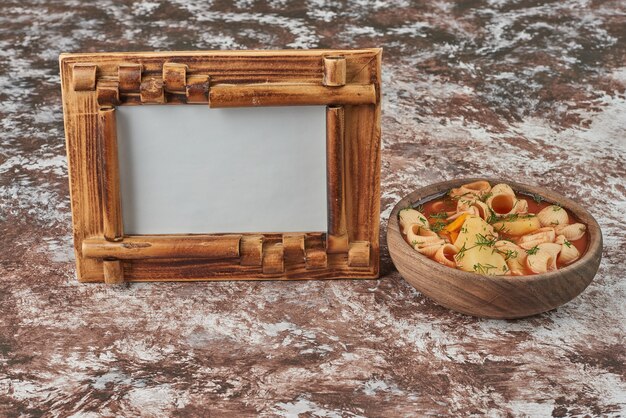 Pasta in zuppa di pomodoro in una tazza di legno.