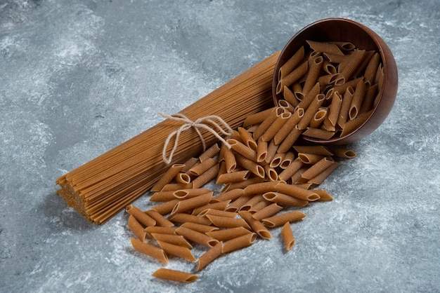 Pasta integrale cruda su marmo.