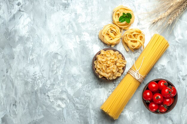 Pasta italiana lunga vista dall'alto con pomodori su sfondo bianco