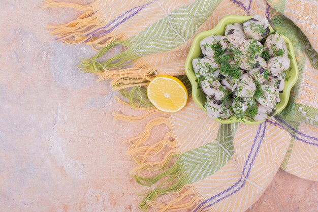 Pasta khinkali caucasica in un piatto verde con erbe e limone