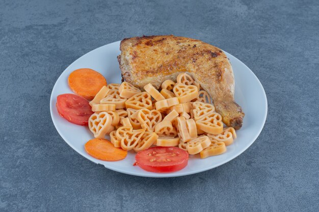 Pasta saporita con pezzi di carne sul piatto bianco.