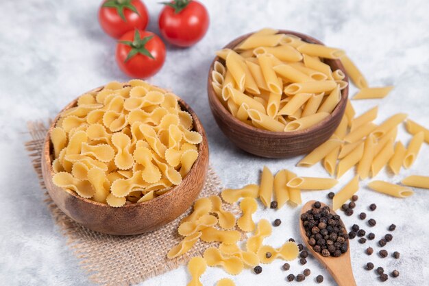 Pasta secca cruda posta su uno sfondo di marmo. Foto di alta qualità