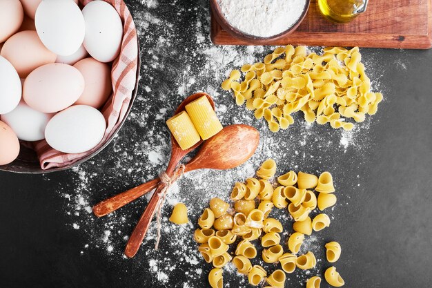 Pasta sulla farina con uova intorno.