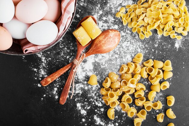 Pasta sulla farina con uova intorno.