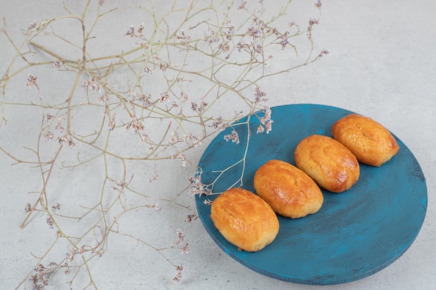 Paste dolci con fiore appassito in piatto blu