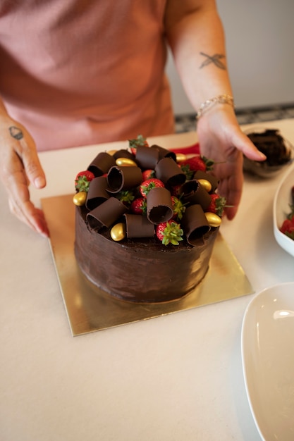 Pasticcere femminile con torta al cioccolato in pasticceria