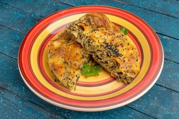 Pasticceria di vista frontale con pasto delizioso della pasta della carne all'interno del piatto sullo scrittorio rustico blu.