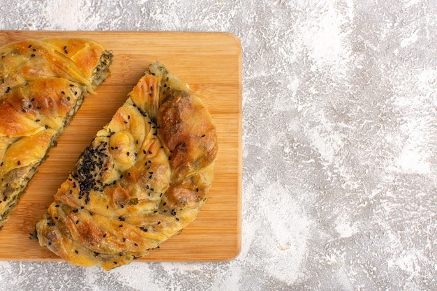 Pasticceria vista ravvicinata dall'alto con delizioso pasto di pasta di carne affettato sulla scrivania a luce bianca.