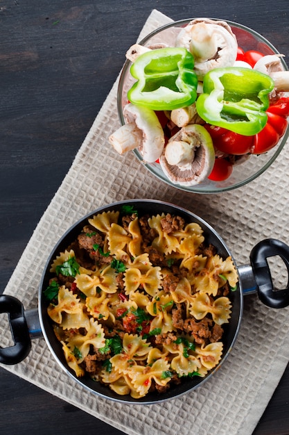 Pasto di pasta in padella con funghi, peperoni, pomodori