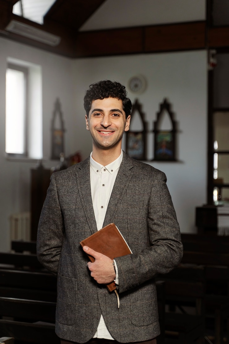 Foto gratuito pastore sorridente del colpo medio che tiene la bibbia