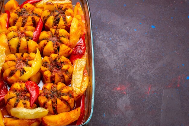 Patate al forno a metà vista ravvicinata con carne macinata all'interno della forma sullo sfondo scuro.