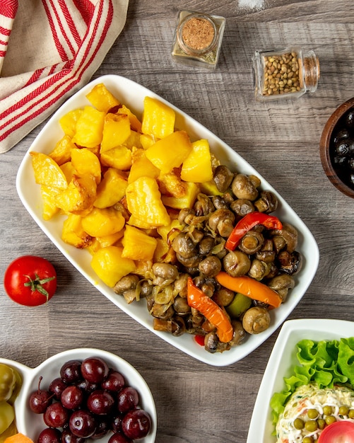 patate con funghi e peperone su un piatto e pomodoro