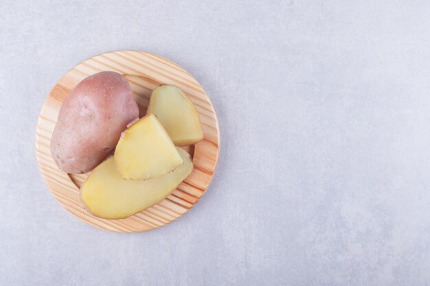 Patate deliziose bollite sul piatto di legno.