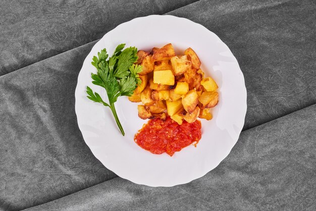 Patate fritte con concentrato di pomodoro ed erbe aromatiche.