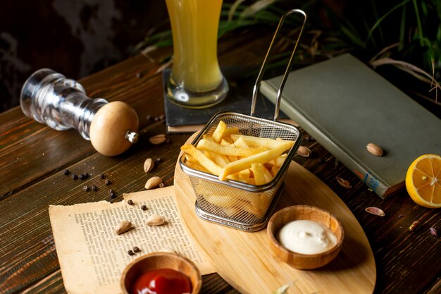 Patate fritte con ketchup e maionese sul tavolo