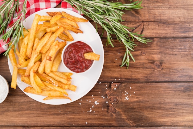 Patate fritte con ketchup squisito sulla tavola di legno