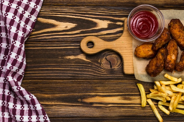 Patate fritte e salsa vicino al pollo