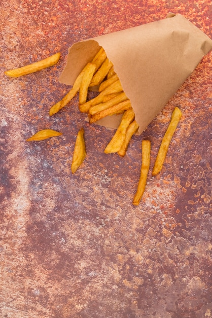 Patate fritte sparse sul tavolo grigio