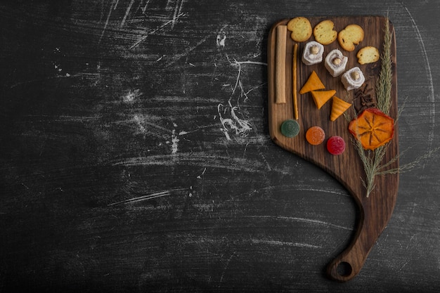 Patatine fritte con prodotti di pasticceria su un piatto di legno, vista dall'alto