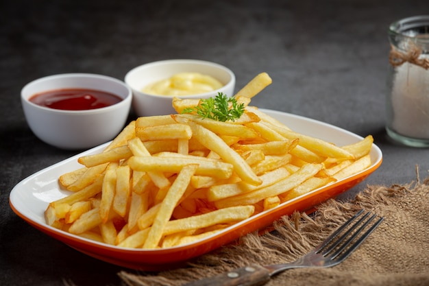 Patatine fritte croccanti con ketchup e maionese.