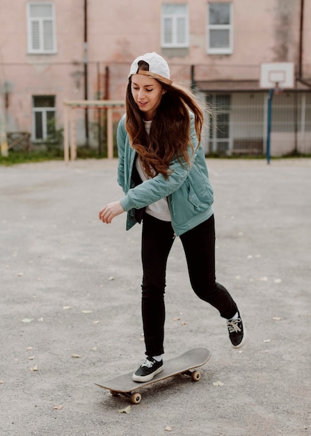 Pattinatore femminile che pratica lo skateboard all'aperto