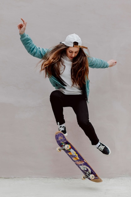 Pattinatore femminile che pratica lo skateboard all'aperto