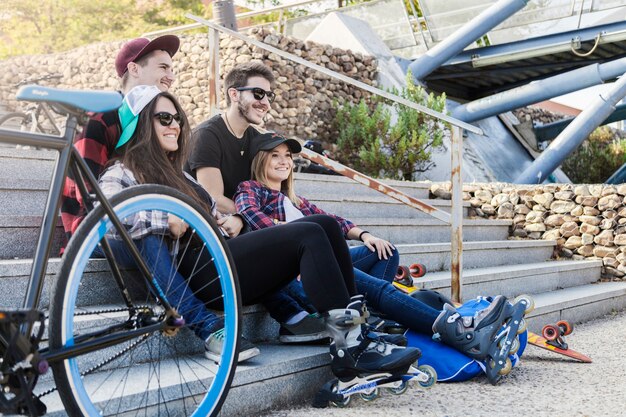 Pattinatori a rotelle che riposano vicino alla bicicletta