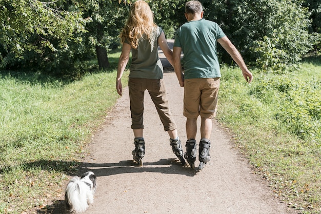 Pattini di rullo d'uso delle coppie che camminano nel parco