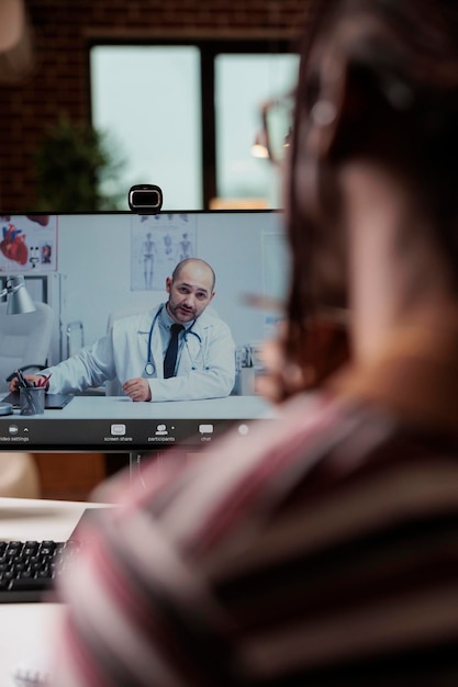 Paziente che parla con il medico in videochiamata, telemedicina, check-up online, consulenza medica specialistica. Donna che chiacchiera con il terapeuta su internet, discutendo di salute con il medico di base