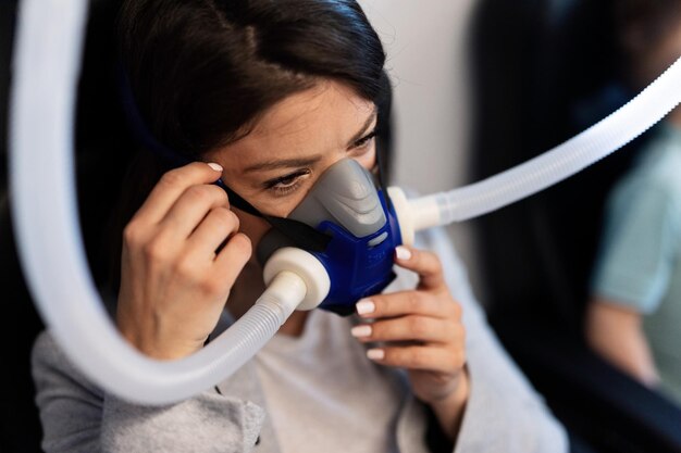 Paziente femminile che mette una maschera di ossigeno durante il trattamento in camera iperbarica