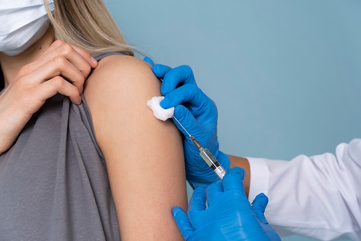 Foto gratuito paziente femminile con maschera medica che riceve un vaccino
