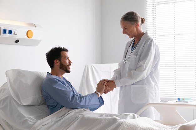 Paziente maschio malato a letto a parlare con un'infermiera