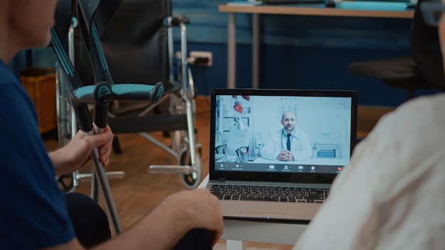 Pazienti in pensione che partecipano alla consultazione in videoconferenza con il medico, parlando di assistenza sanitaria. Coppia che utilizza la videochiamata online per la telemedicina e la telemedicina con uno specialista sul laptop.