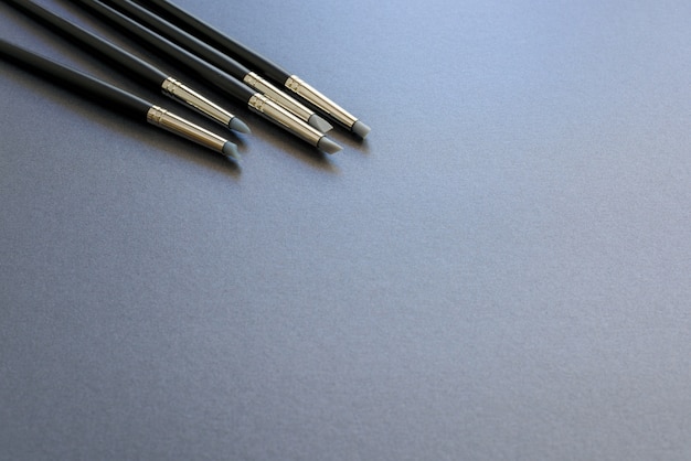 Penna di punta del silicone di fornitura di arte isolata su priorità bassa grigio scuro.