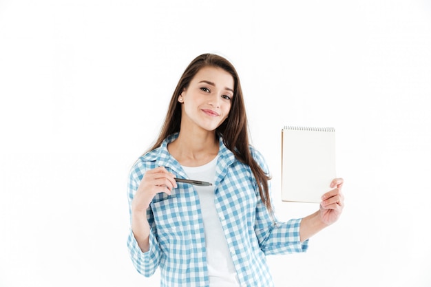 Penna di puntamento graziosa della donna graziosa al blocco note della carta in bianco