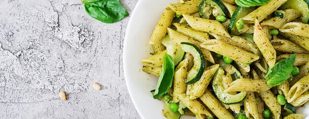 Penne al pesto, zucchine, piselli e basilico. Cibo italiano. Vista dall'alto. Disteso