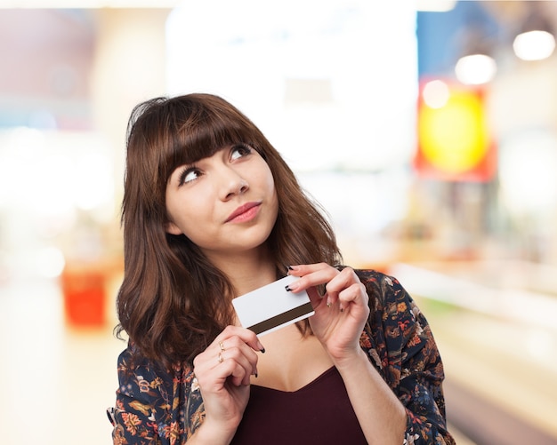 Pensieroso donna con una carta di credito