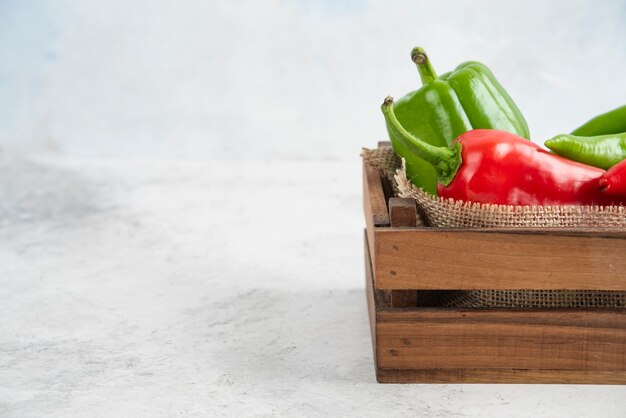 Peperoncini rossi e verdi in un vassoio di legno.