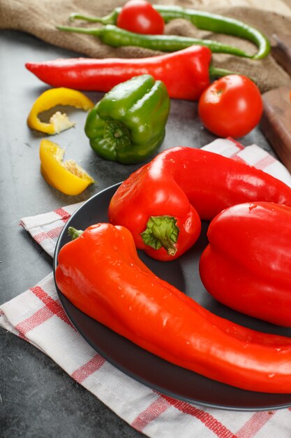 Peperoncini rossi freschi colorati in un piatto di ceramica nera.