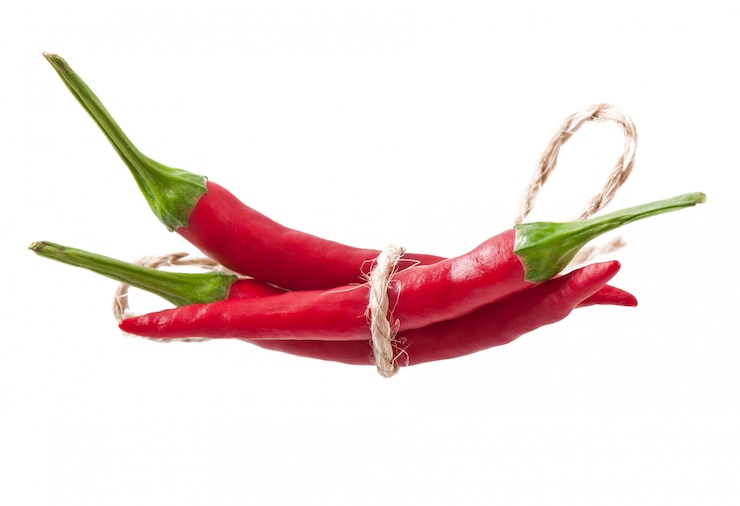 Foto gratuito peperoncini roventi legati con la corda su bianco