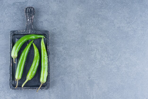 Peperoncini verdi su tavola di legno.