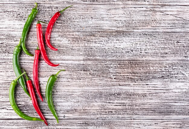 Peperoncino di vista superiore con lo spazio della copia a destra su di legno bianco