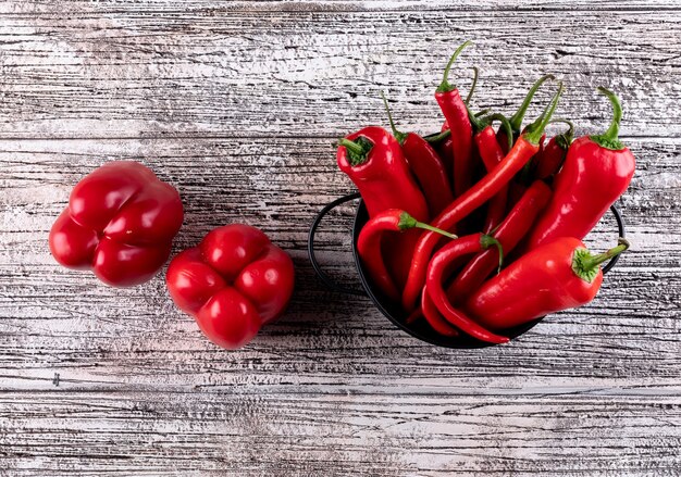 Peperoncino rosso del peperone dolce del peperone di vista superiore in pentola nera sull'orizzontale di legno bianco