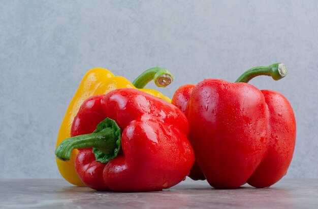 Peperoni interi saporiti su fondo di marmo. Foto di alta qualità