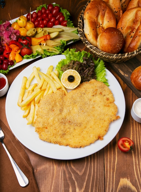 Pepita di pollo arrosto, petto con patatine fritte. Servito con insalata di verdure e varietà di turshu