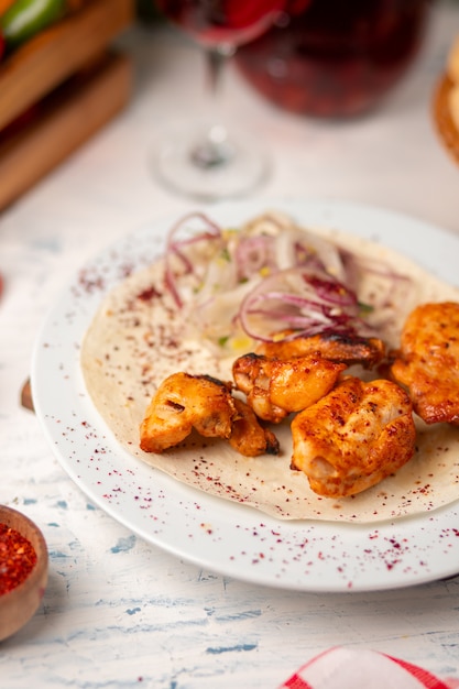 Pepite di pollo alla griglia, ali, petto con insalata di cipolle