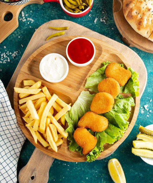 Pepite di pollo fritto con la vista superiore delle patate fritte