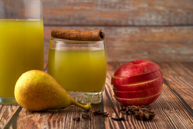 Pera verde e mela rossa con un bicchiere di succo